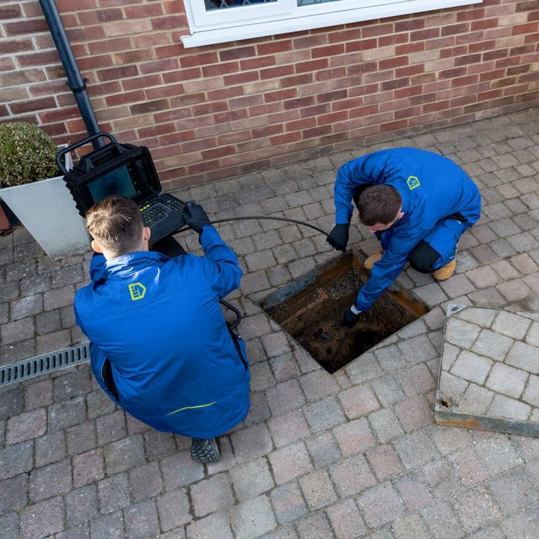 Two drainage engineers conducting a CCTV drain survey at a residential property.