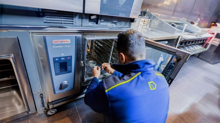 An Aspect commercial gas engineer repairing an oven in a commercial kitchen.