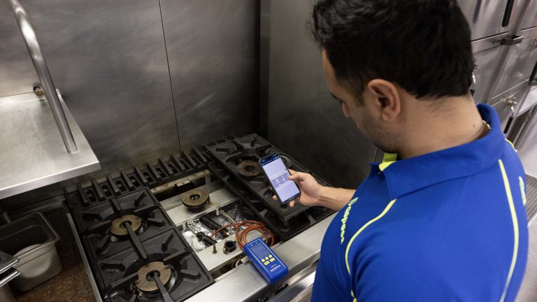 An Aspect gas engineer safety checks a gas stove following repairs.