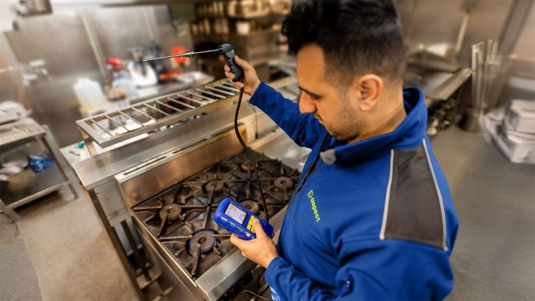An Aspect engineer doing gas safety checks in a commercial kitchen.