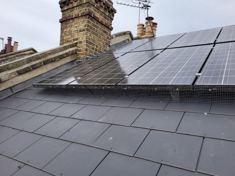 Wire mesh fitted around solar panels on the pitched roof of a property to prevent pigeon from perching on them or nesting beneath them