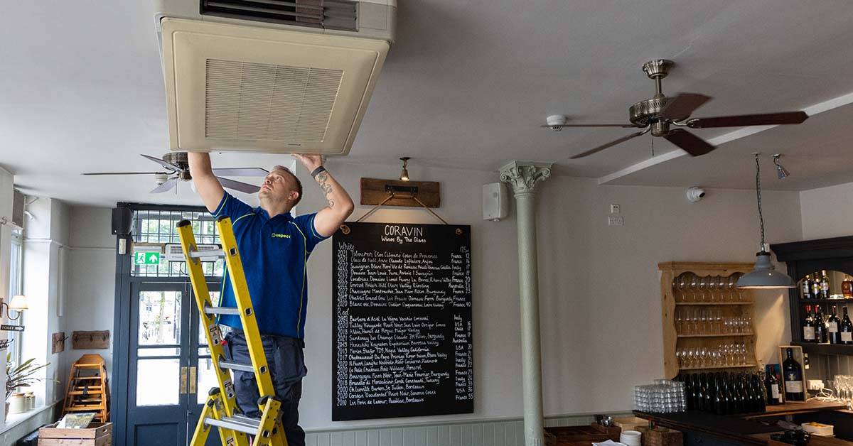 An Aspect air conditioning specialist working on the internal part of a commercial system