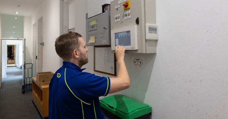 An Aspect air conditioning specialist checks the control panel of a commercial AC system as part of a planned maintenance visit