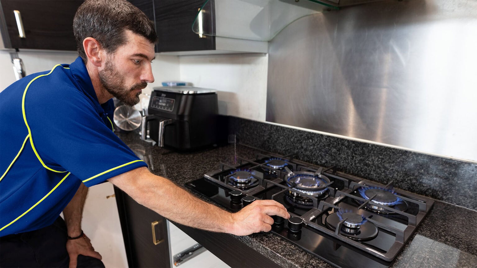 An Aspect Gas Safe engineer installing a new gas hob in a domestic kitchen