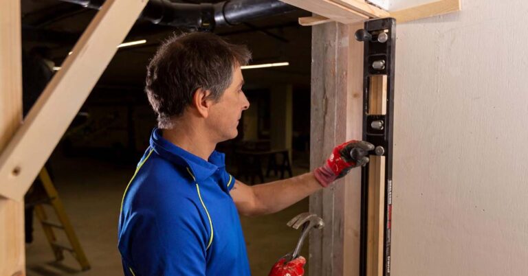 An Aspect carpenter installaing a new door frame for a fire door to be installed leading to an underground car park.