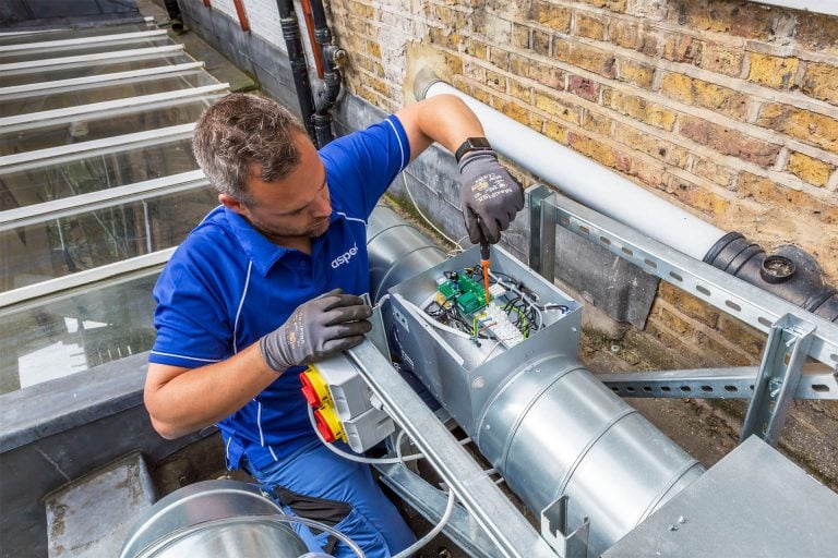 An Aspect tradesperson carries out checks on the exterior part of a commercial kitchen ventilation installation.