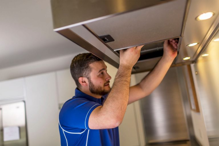 An Aspect tradesperson carries out a new cooker hood installation in a domestic kitchen.