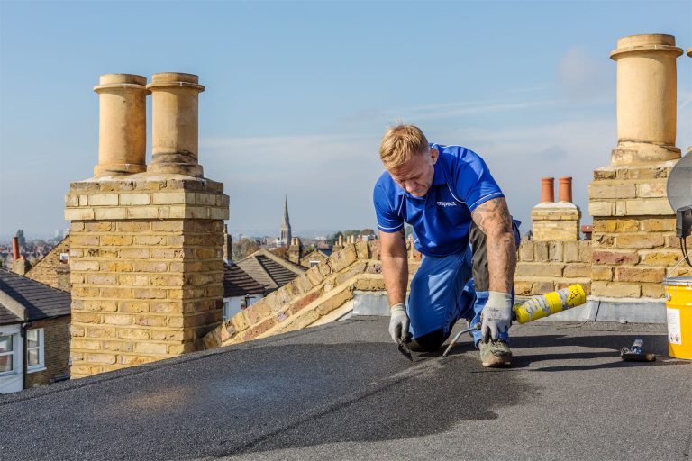 An Aspect uses a gas torch for flat roof repair to a mineral felt roof covering.