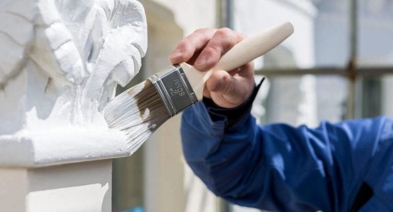 An Aspect painter decorator painting exterior masonry.