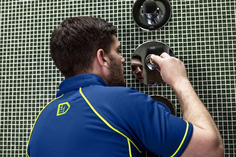 An Aspect bathroom plumber repairs a broken shower mixer.