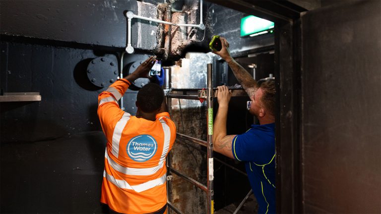 An Aspect emergency plumber working on a water supply pipe with a Thames Water engineer.