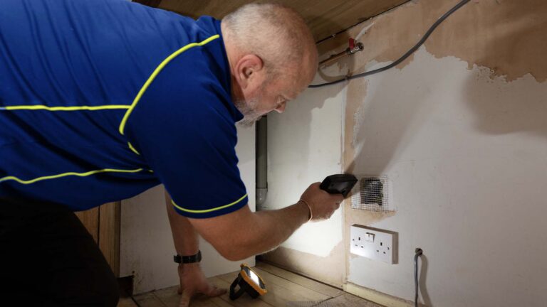 An Aspect pest controller fitting wire mesh to a hole in plasterboard that rodents use to enter a kitchen